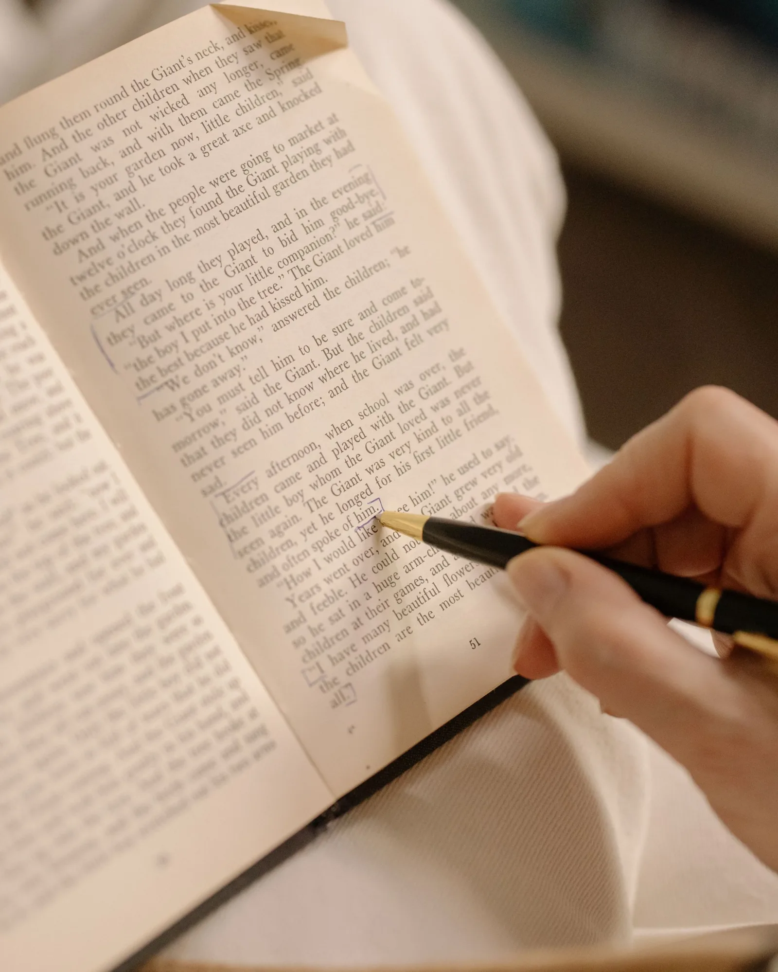 Main qui annote au stylo un texte imprimé, page soulignée